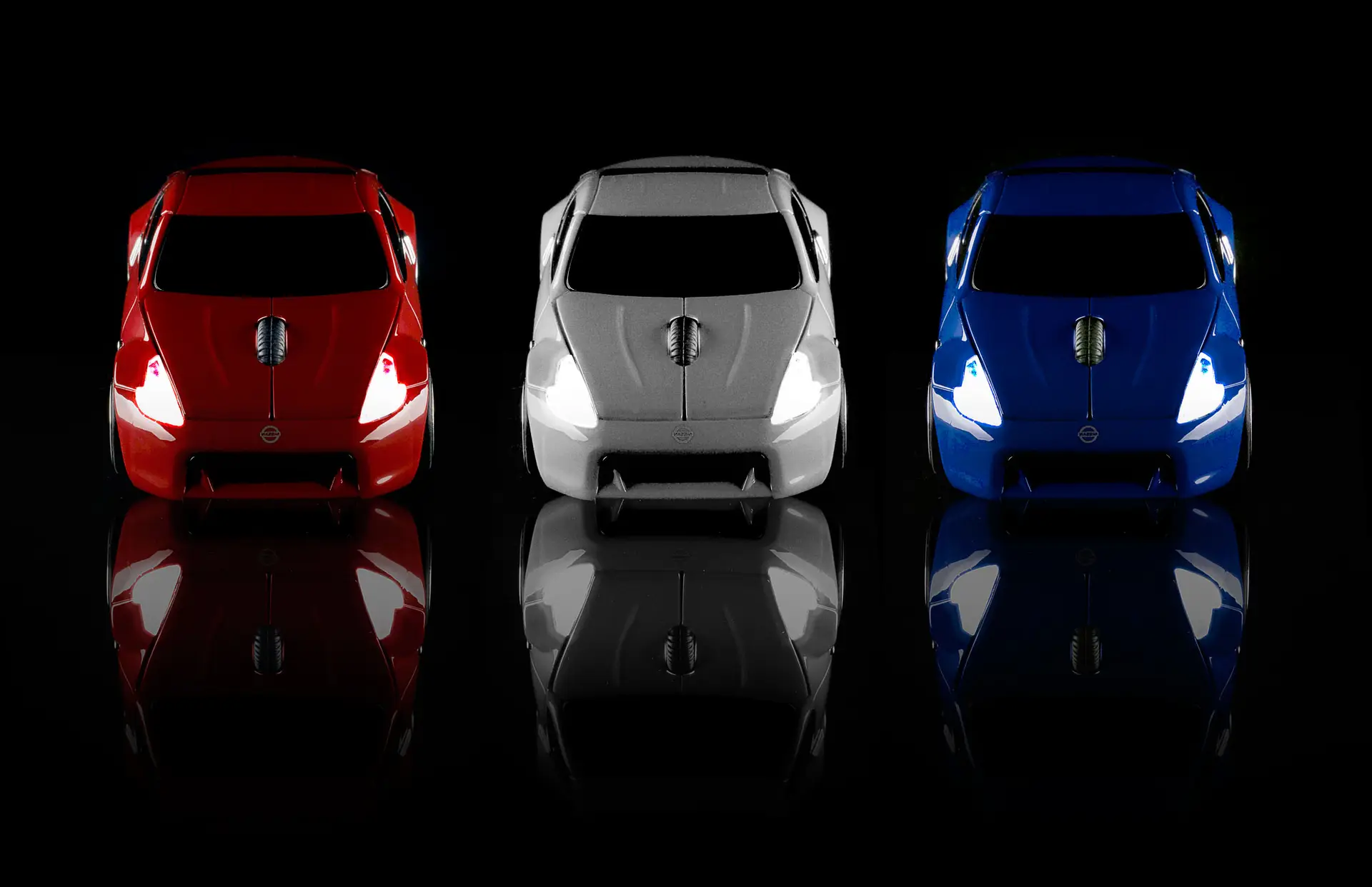 A red, silver and blue Nissan Car shaped computer mouse on a dark background